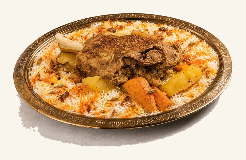 Slow-roasted meat with potato and carrot over saffron Mandi rice on a brass platter