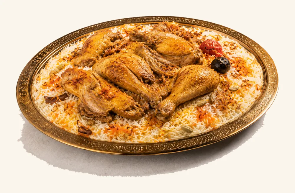 Golden roast chicken pieces over Mandi rice on a brass platter